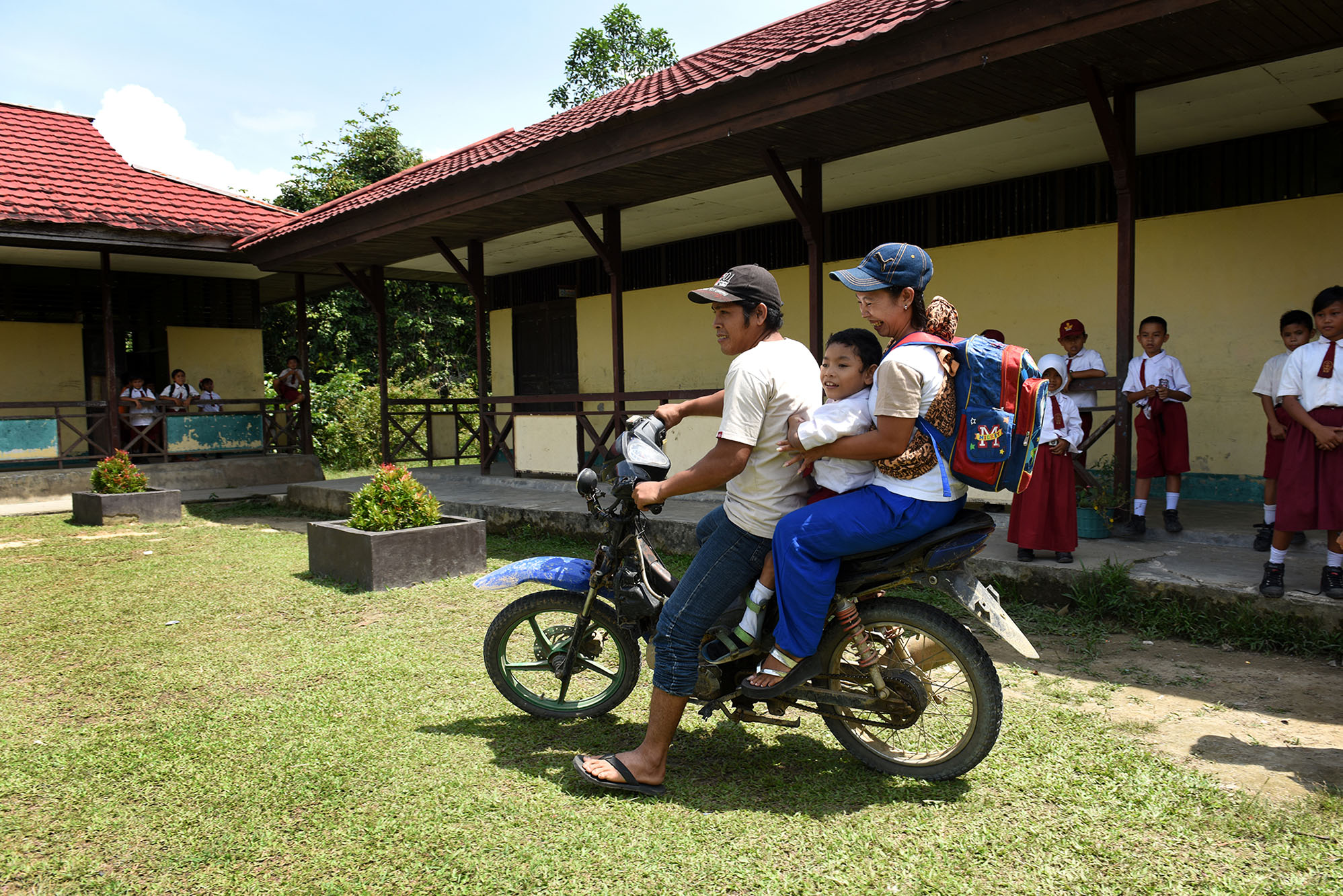 Ouders brengen Moses op brommer naar school