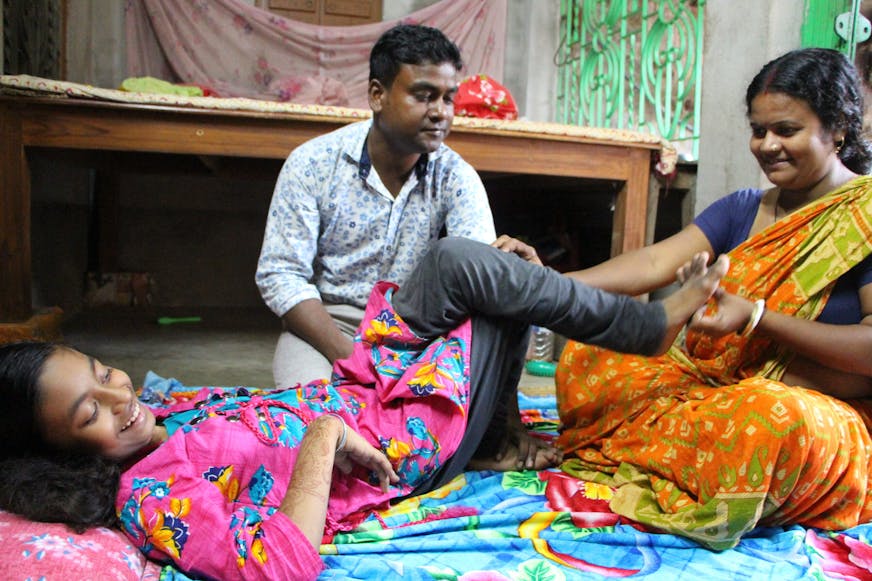 Fysiotherapeut Balai leert de moeder van Anushree hoe ze oefeningen kan doen met haar dochter