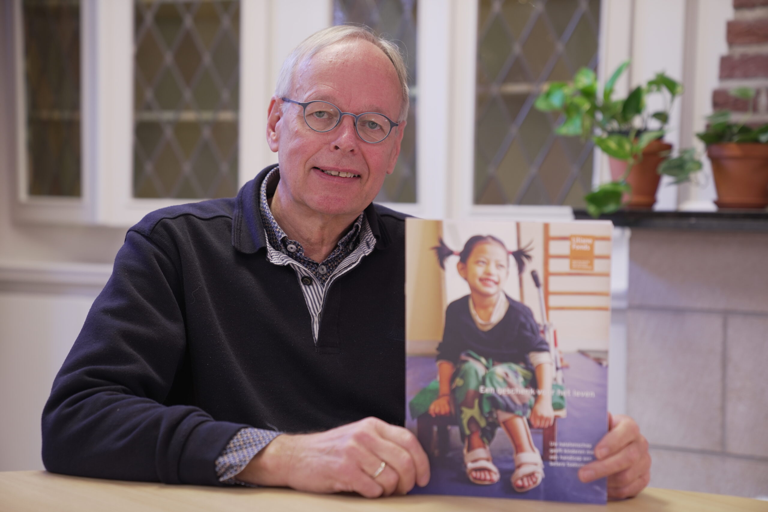 Aad poseert met de Nalatenbrochure