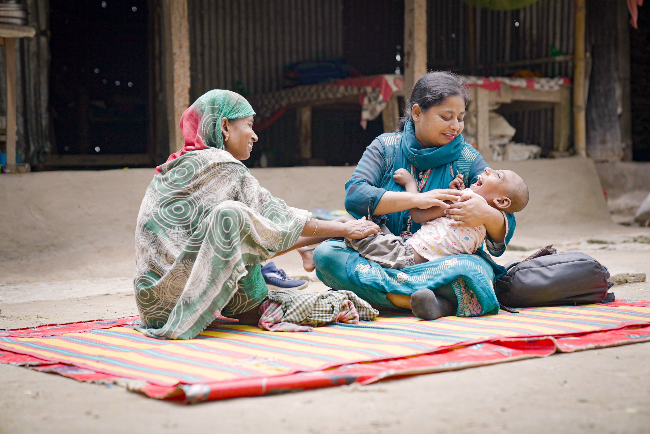 Jesan uit Bangladesh met zijn moeder en een hulpverlener